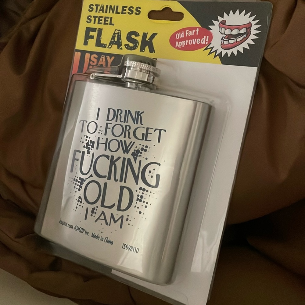 Stainless steel flask that says “ I drink to forget how fucking old I am”